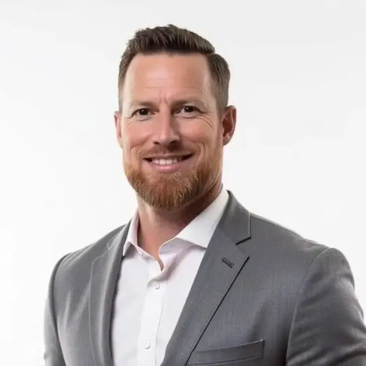 Person in light gray suit jacket and white shirt – professional appearance in a medical or corporate setting.