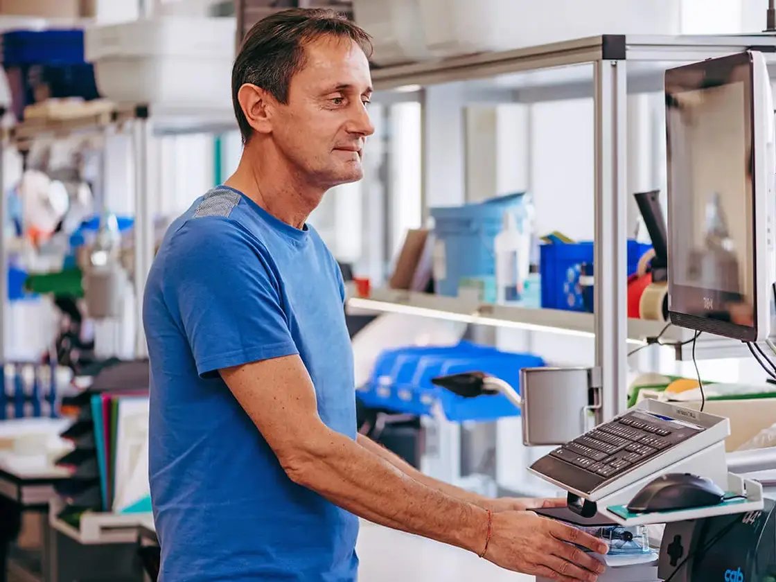 sutter-produktion-mitarbeiter-an-maschine.jpg Ein Mitarbeiter von Sutter Medizintechnik bedient eine Fertigungsmaschine in der Produktion – Fokus auf Präzision und Effizienz