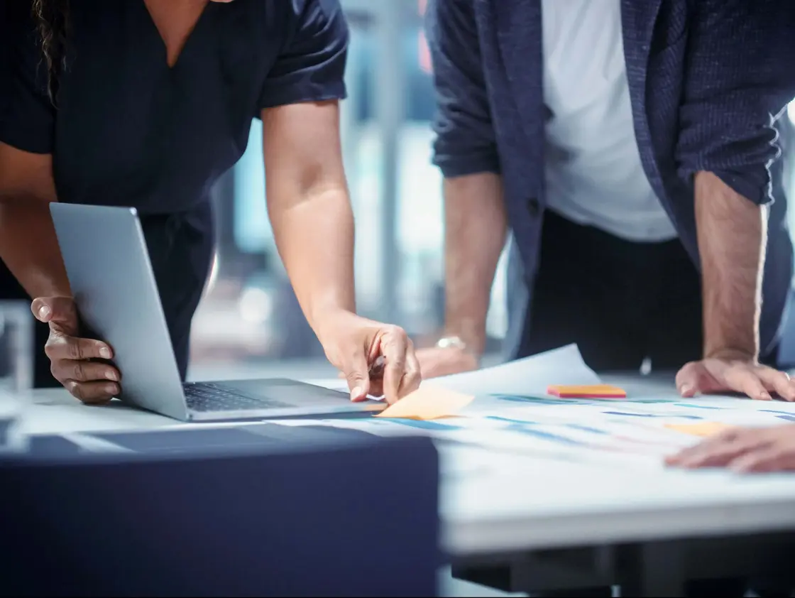 sutter-teamwork-projektplanung.jpg Nahaufnahme von Teammitgliedern bei der gemeinsamen Projektplanung – Strategiemeeting mit Unterlagen und Laptop