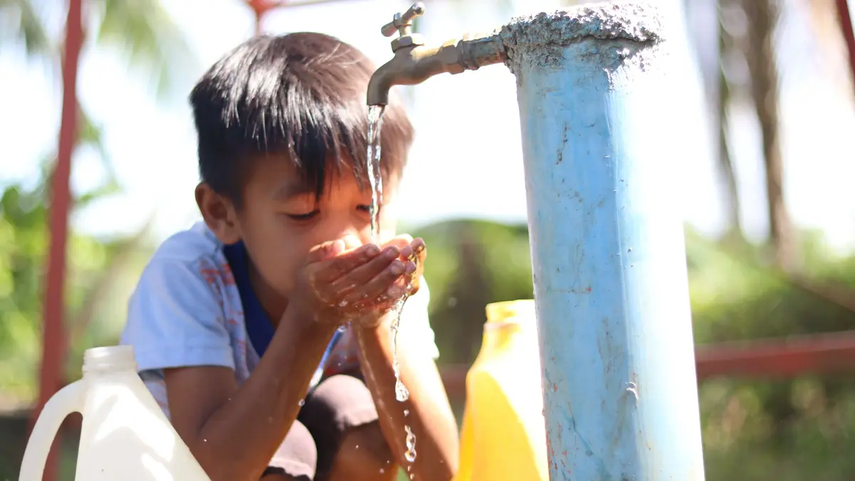 © WorldVision Ein Kind trinkt sauberes Wasser aus einem Wasserhahn – Symbol für das Ziel SDG 6: Zugang zu sicherem Trinkwasser weltweit.