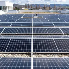 photovoltaikanlage-sutter.jpg Blick auf eine großflächige Photovoltaikanlage auf dem Flachdach von Sutter Medizintechnik in Emmendingen mit sonnigem Himmel und Schwarzwaldpanorama im Hintergrund.