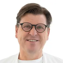 Prof. Dr. Torstein R. Meling mit Brille und in Arztkittel vor weißem Hintergrund.