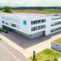 Luftaufnahme des modernen Firmengebäudes von Sutter Medizintechnik in Emmendingen mit Blick auf das Umfeld und angrenzende Felder. ChatGPT fragen